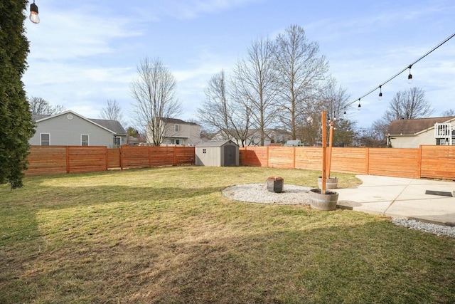 view of yard with an outdoor structure, a storage unit, a patio area, and a fenced backyard