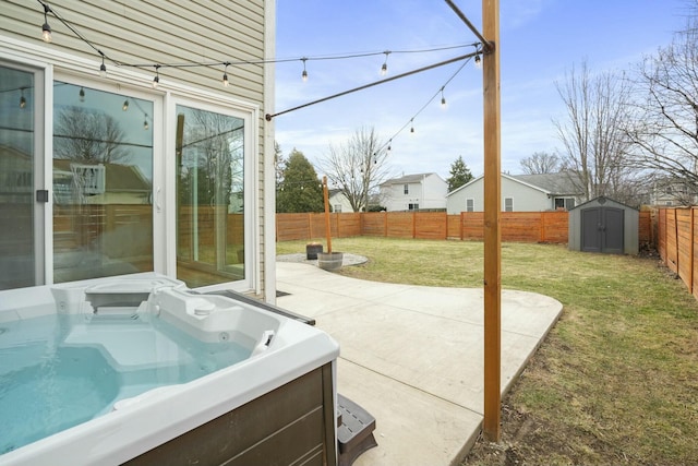 view of patio with a storage unit, an outdoor structure, a fenced backyard, and a hot tub