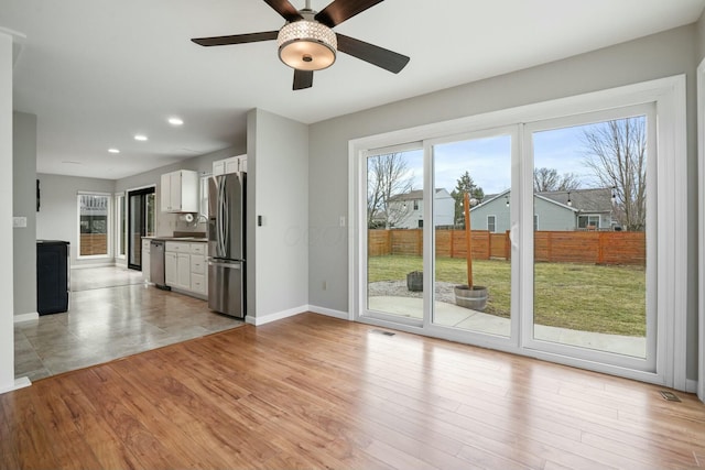 unfurnished living room featuring light wood-type flooring, visible vents, a ceiling fan, recessed lighting, and baseboards