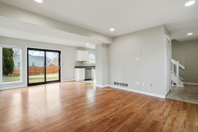 unfurnished living room featuring recessed lighting, visible vents, light wood finished floors, and baseboards