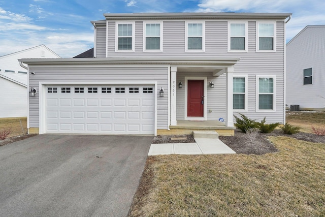 view of front of home with central air condition unit, a front yard, a garage, and driveway