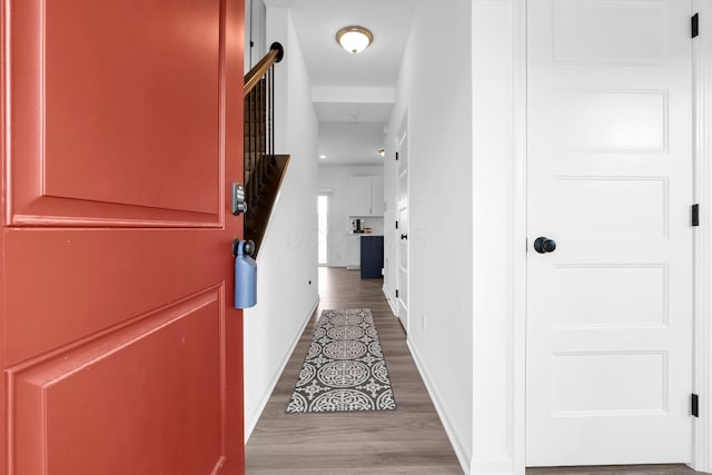 corridor featuring baseboards and wood finished floors