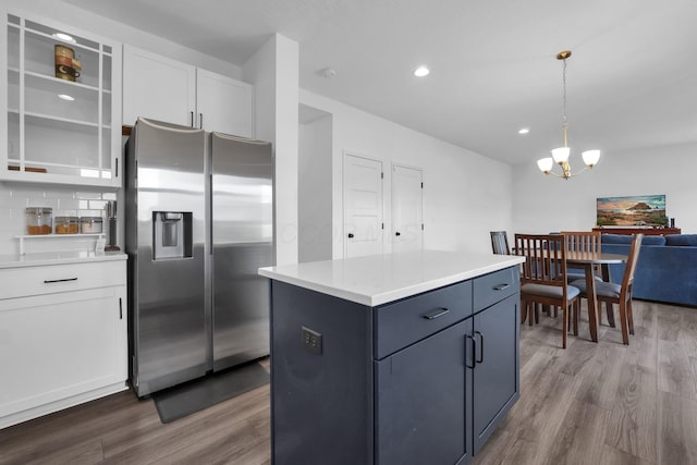 kitchen featuring wood finished floors, white cabinets, stainless steel fridge with ice dispenser, and light countertops