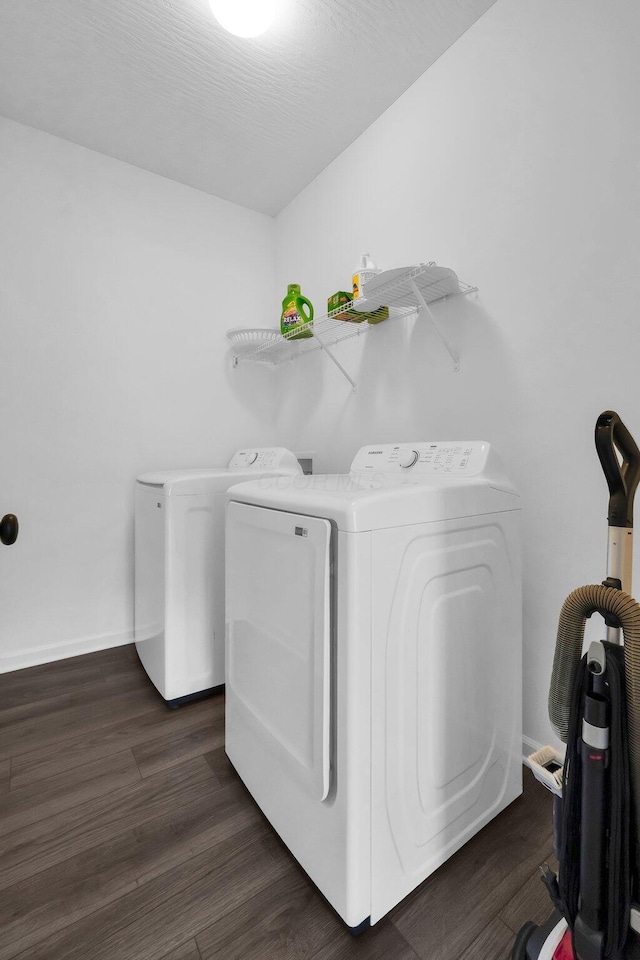 washroom featuring baseboards, separate washer and dryer, dark wood-style flooring, and laundry area