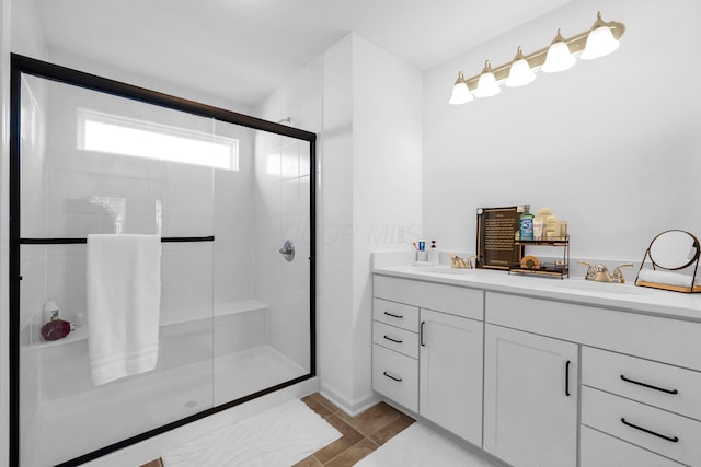 full bathroom featuring a shower stall, double vanity, tile patterned floors, and a sink