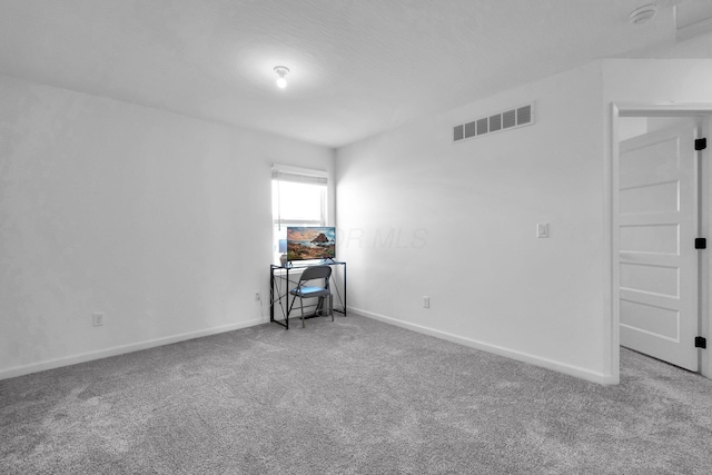 empty room with carpet flooring, baseboards, and visible vents