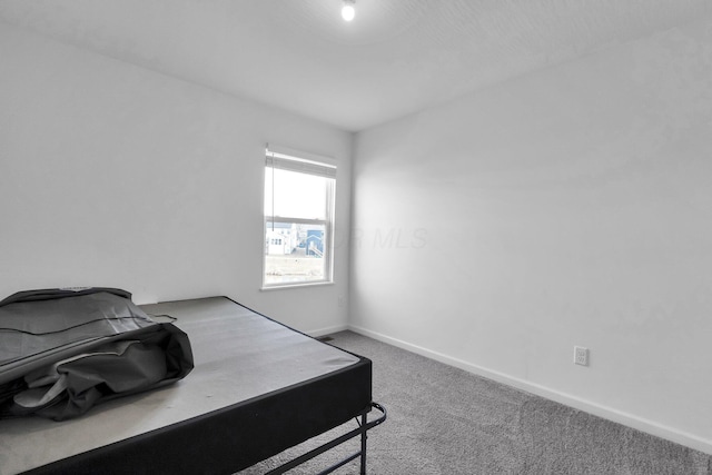 bedroom with baseboards and carpet