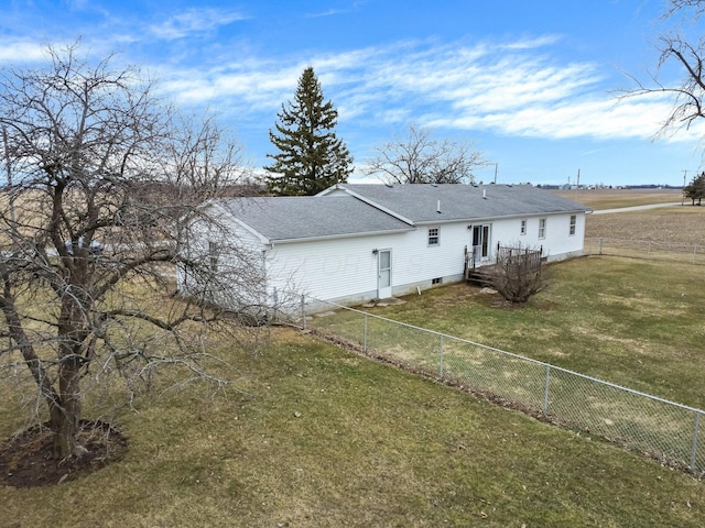 back of property featuring a shingled roof, a fenced backyard, and a lawn