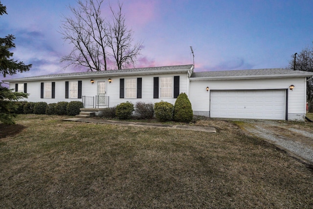 ranch-style home featuring driveway, an attached garage, and a lawn