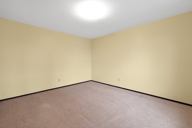 empty room with baseboards and light colored carpet