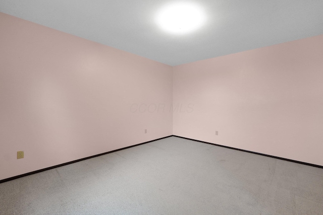 unfurnished room with light colored carpet and baseboards