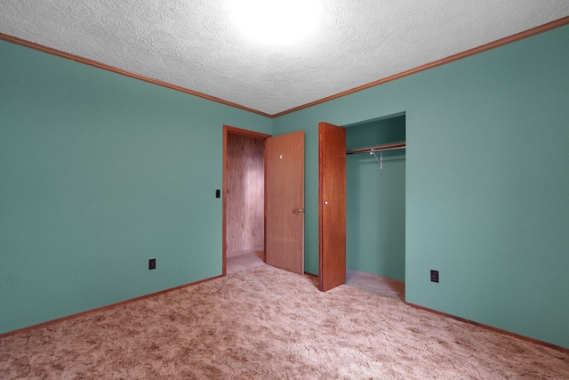 unfurnished bedroom featuring carpet floors, a textured ceiling, a closet, and crown molding