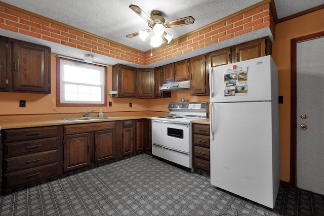 kitchen with light countertops, a sink, a textured ceiling, white appliances, and under cabinet range hood