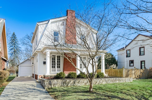 dutch colonial featuring fence, a gambrel roof, a chimney, an outdoor structure, and a garage