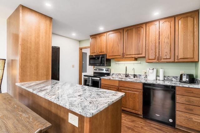 kitchen with stainless steel range with electric stovetop, light stone countertops, dishwasher, and a sink