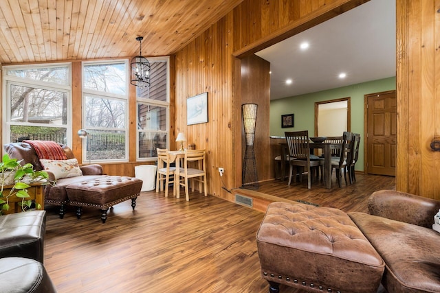 living area featuring wooden walls, a chandelier, wood ceiling, vaulted ceiling, and wood finished floors