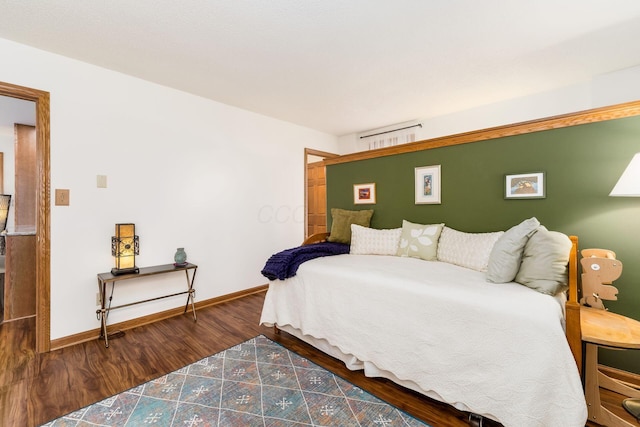 bedroom with baseboards and wood finished floors