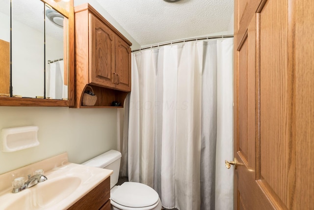 full bathroom featuring a shower with shower curtain, a textured ceiling, vanity, and toilet