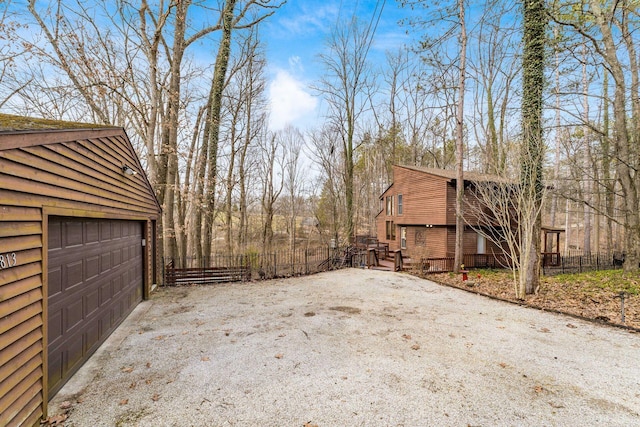 view of property exterior featuring a detached garage, an outbuilding, and fence