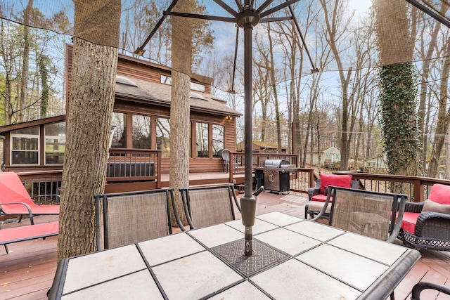 wooden deck with outdoor dining area and grilling area