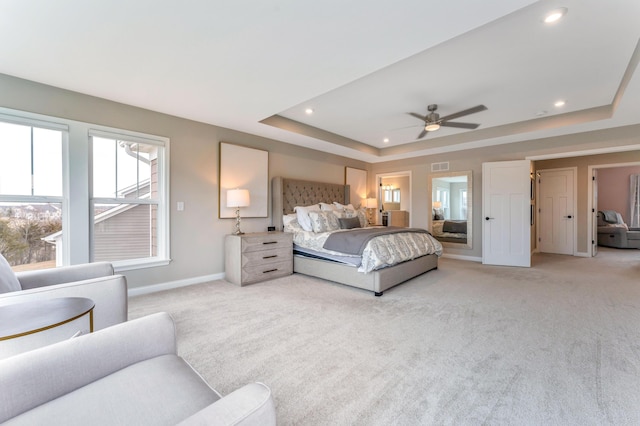 bedroom featuring visible vents, baseboards, light colored carpet, recessed lighting, and a raised ceiling