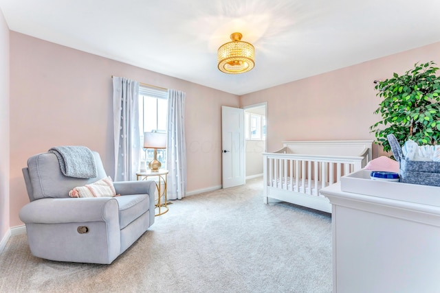 bedroom featuring baseboards, light carpet, and a crib