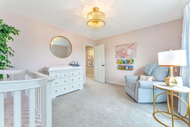 bedroom featuring a nursery area, baseboards, and carpet floors