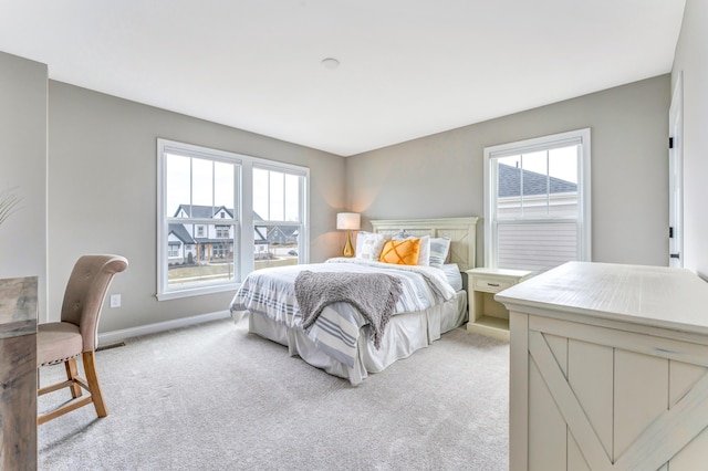 bedroom with light carpet and baseboards