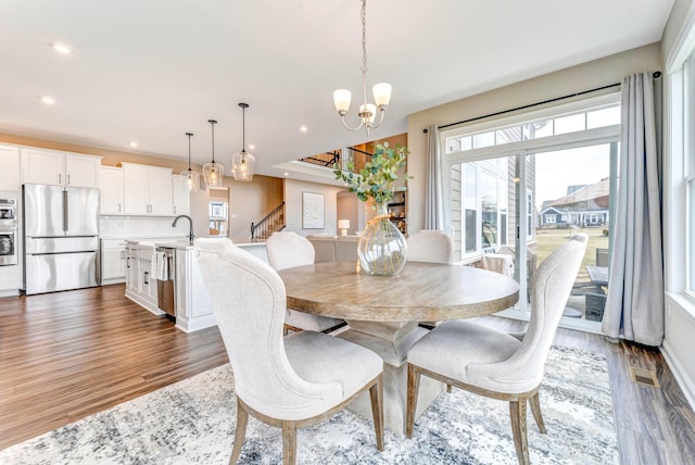 dining room with plenty of natural light, a notable chandelier, and wood finished floors