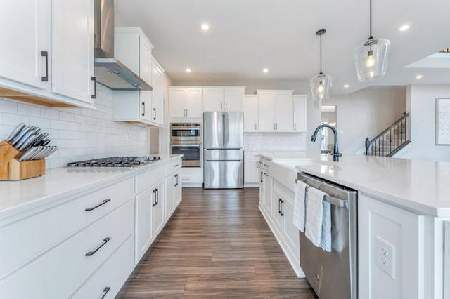 kitchen featuring light countertops, stainless steel appliances, white cabinetry, wall chimney exhaust hood, and dark wood-style flooring