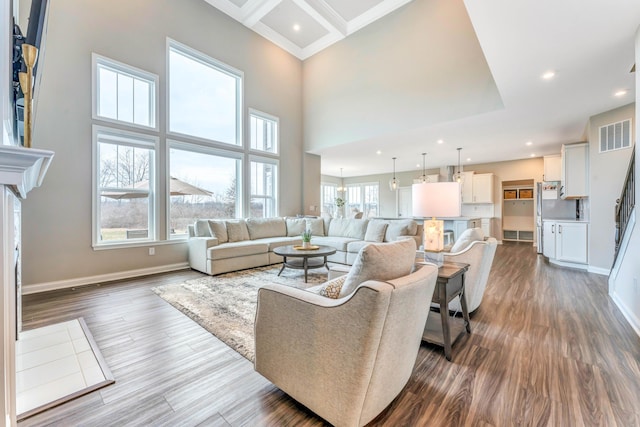 living area featuring visible vents, baseboards, recessed lighting, a high ceiling, and dark wood-style flooring