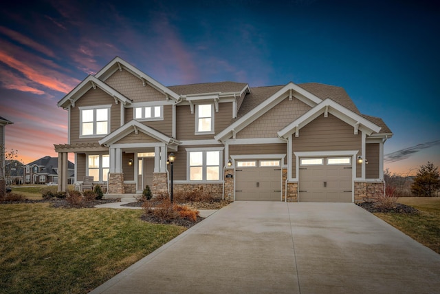 craftsman-style home with concrete driveway, a lawn, a garage, and stone siding