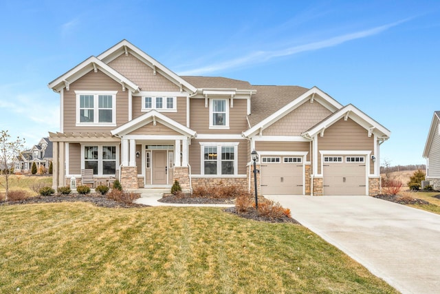 craftsman-style home featuring a front yard, stone siding, and driveway