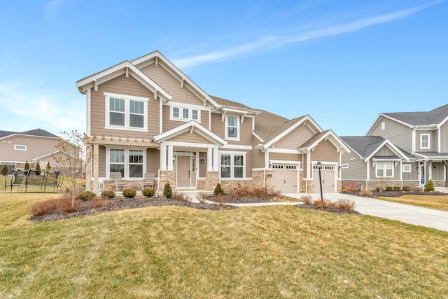 craftsman house with a front yard, fence, concrete driveway, a garage, and stone siding