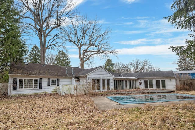 back of property featuring a fenced in pool and fence