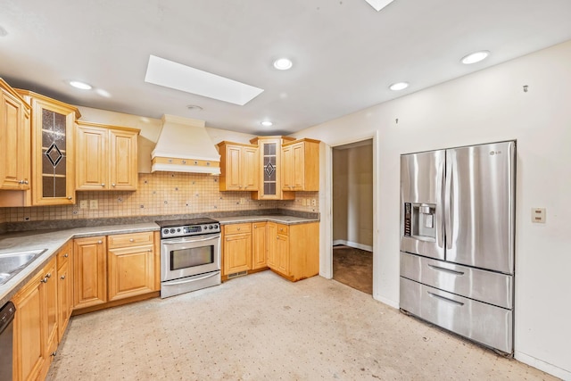 kitchen with decorative backsplash, custom range hood, glass insert cabinets, and appliances with stainless steel finishes