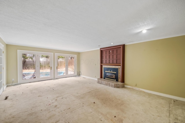 unfurnished living room featuring visible vents, crown molding, baseboards, carpet flooring, and a fireplace