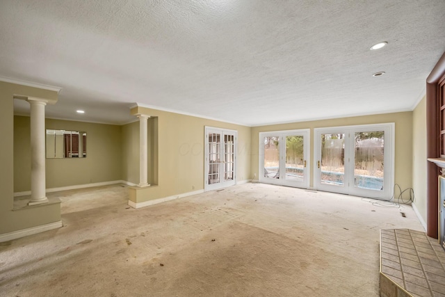 spare room with decorative columns, baseboards, and a textured ceiling