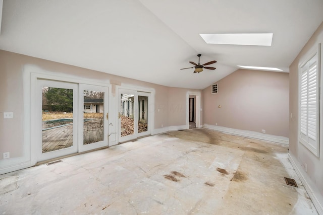 empty room with lofted ceiling with skylight, visible vents, and baseboards