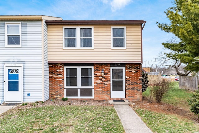 view of front facade featuring brick siding and a front yard