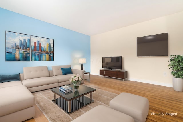 living room featuring a city view, baseboards, and wood finished floors