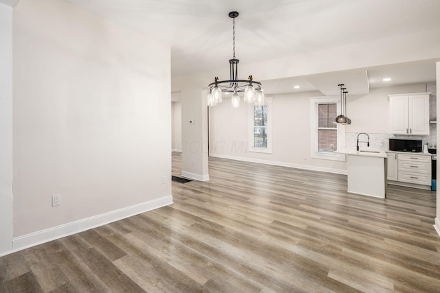 interior space with a sink, baseboards, and light wood-style floors