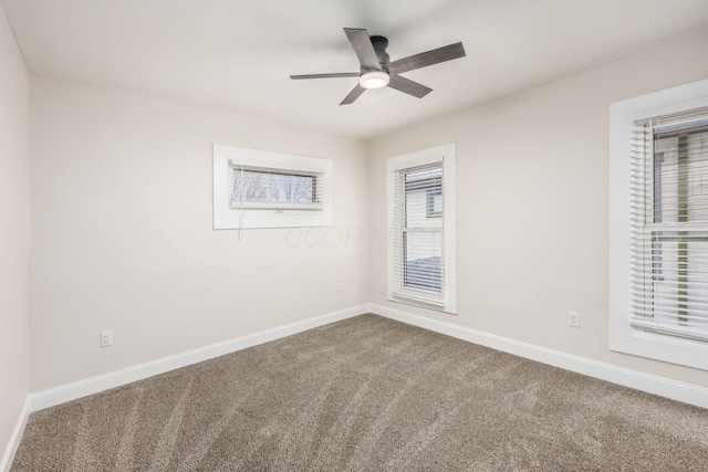 empty room featuring baseboards, a ceiling fan, and carpet flooring