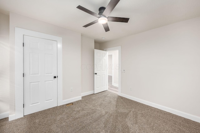 unfurnished bedroom featuring carpet flooring, visible vents, baseboards, and ceiling fan