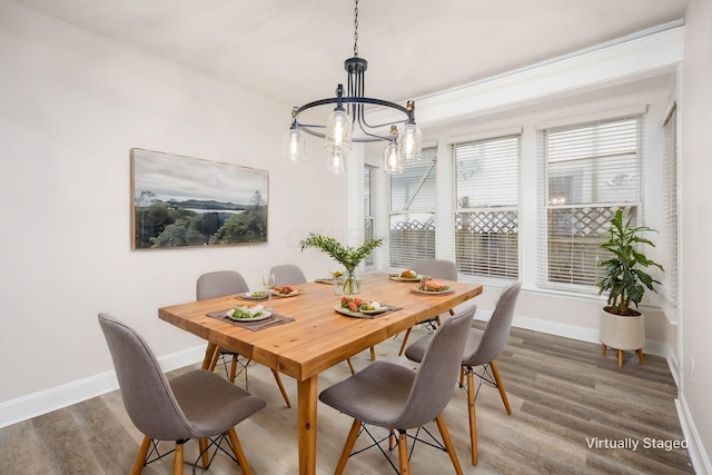 dining space with an inviting chandelier, wood finished floors, and baseboards