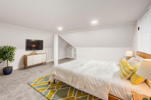 carpeted bedroom with lofted ceiling and baseboards