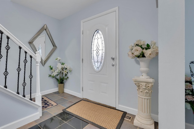 foyer featuring stairway and baseboards