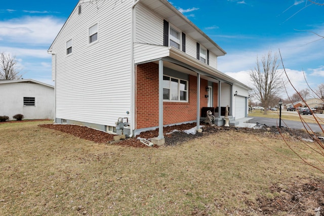 view of home's exterior featuring driveway, brick siding, an attached garage, and a lawn