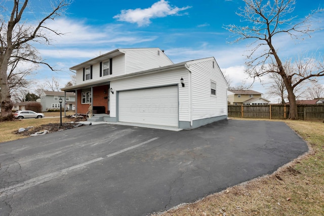 view of front of property featuring a garage, driveway, and fence