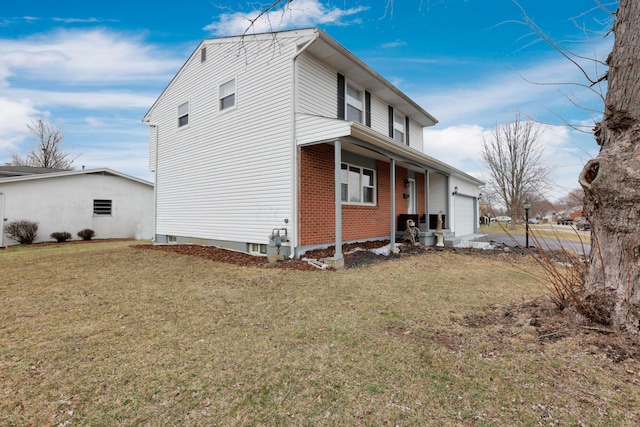 exterior space featuring a yard, brick siding, and a garage